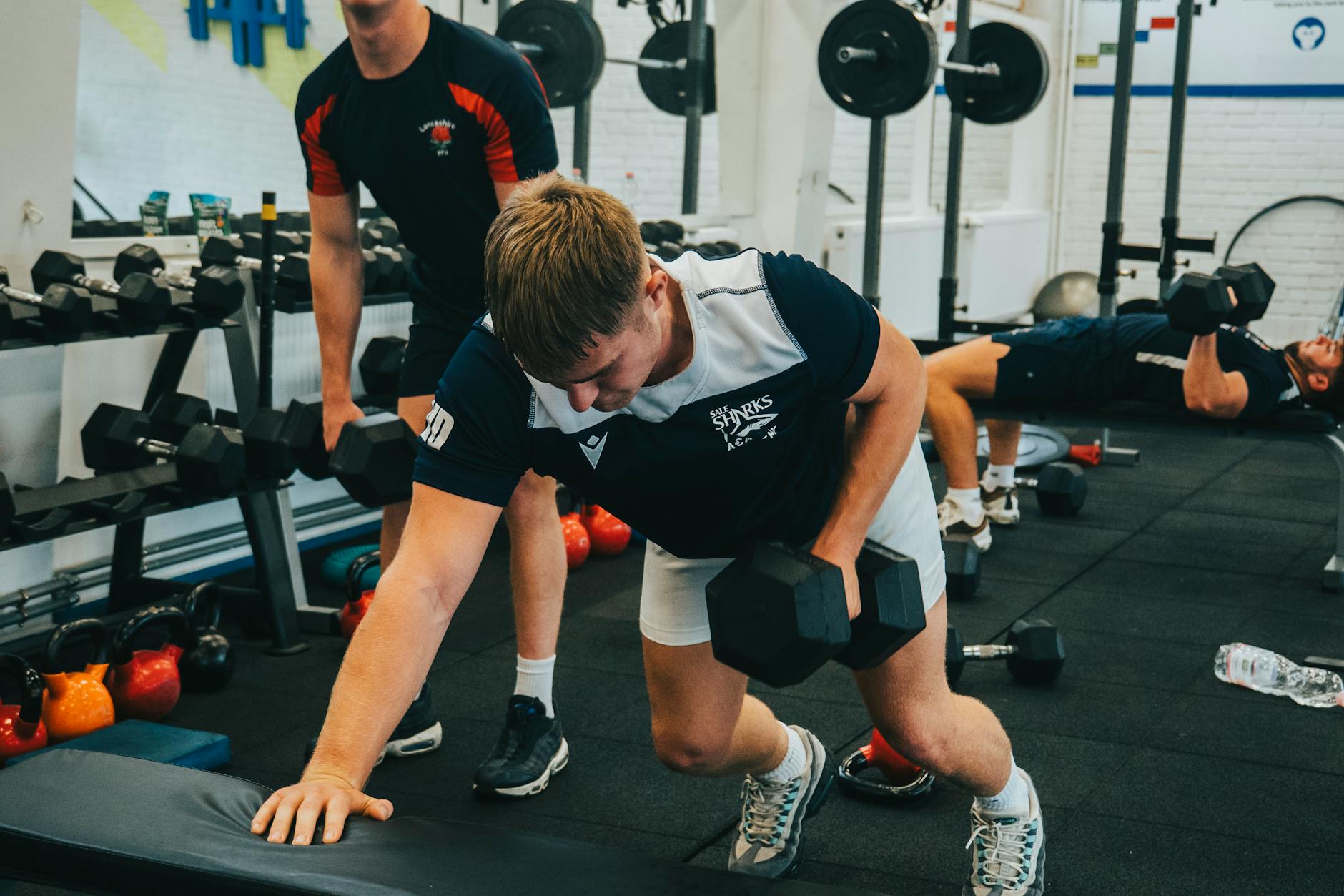 men exercising with dumbbells in gym